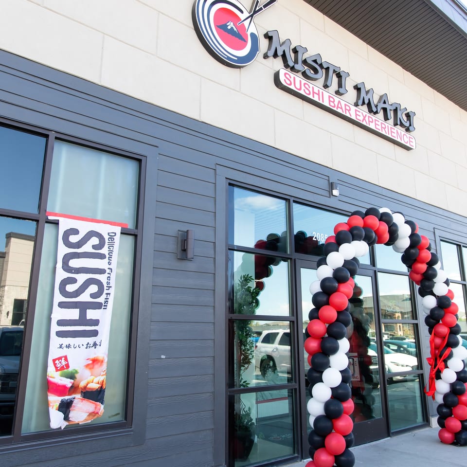 Misti Mats Sushi Bar Experience storefront with a red, white, and black balloon arch for an opening.