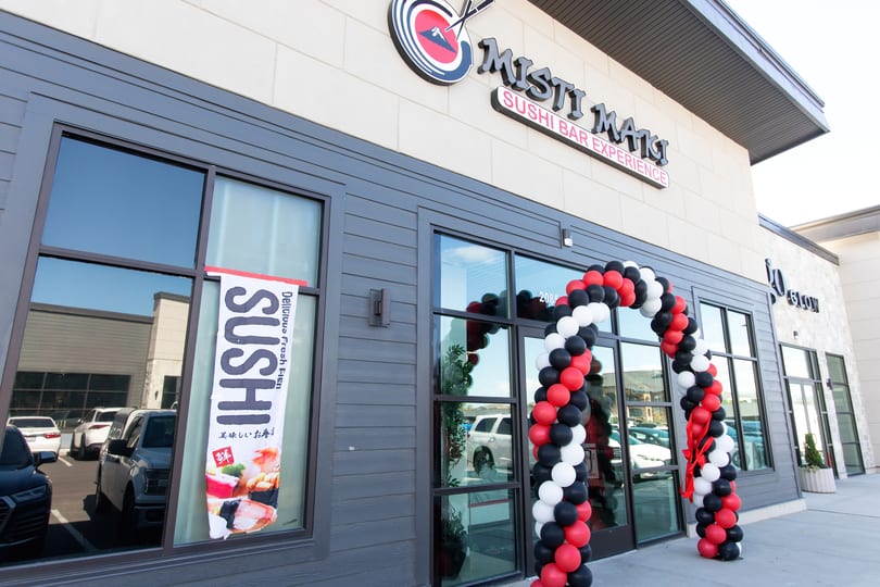 Misti Mats Sushi Bar Experience storefront with a red, white, and black balloon arch for an opening.